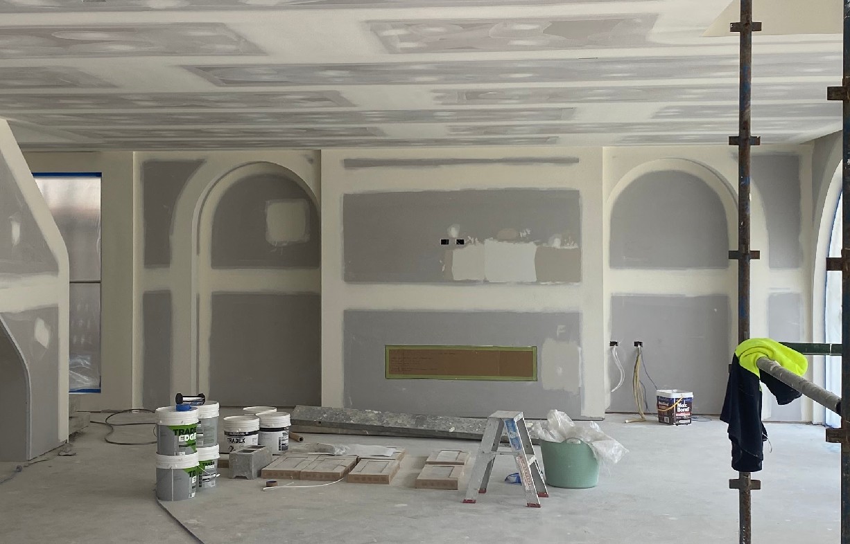 Plasterer finishing a newly set plasterboard wall