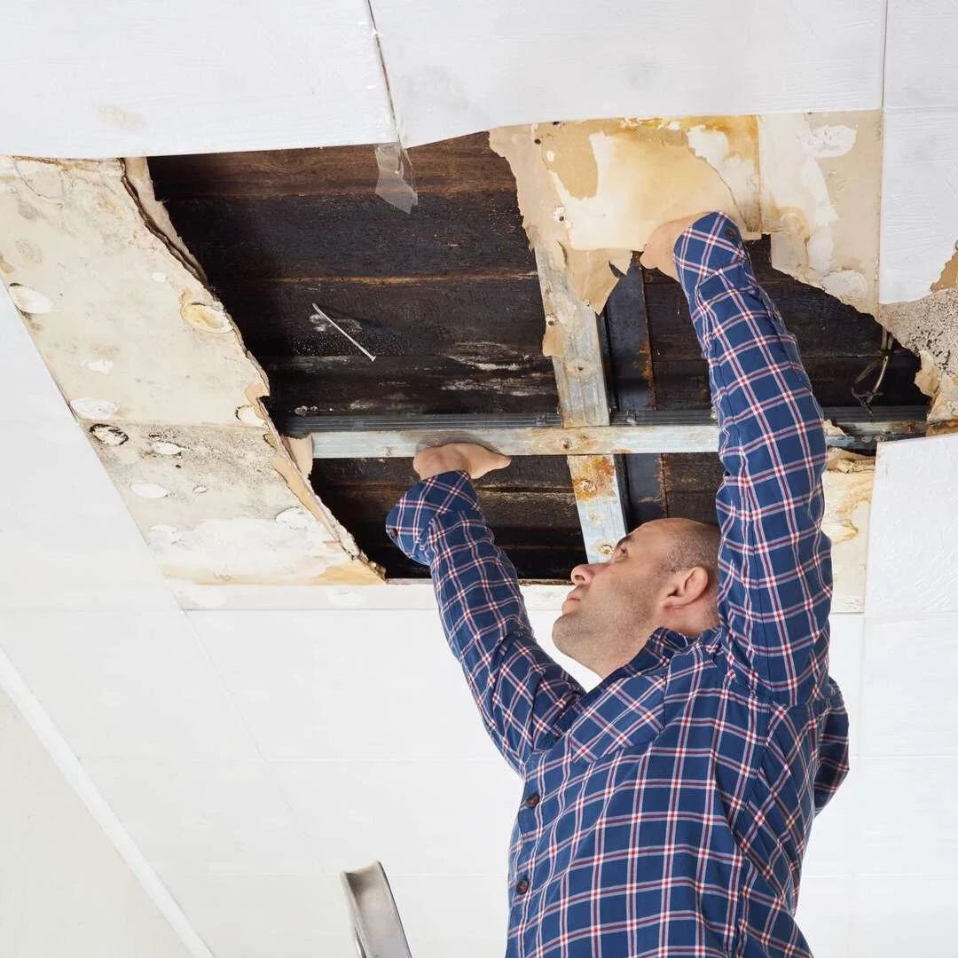Plasterer fixing a damaged ceiling