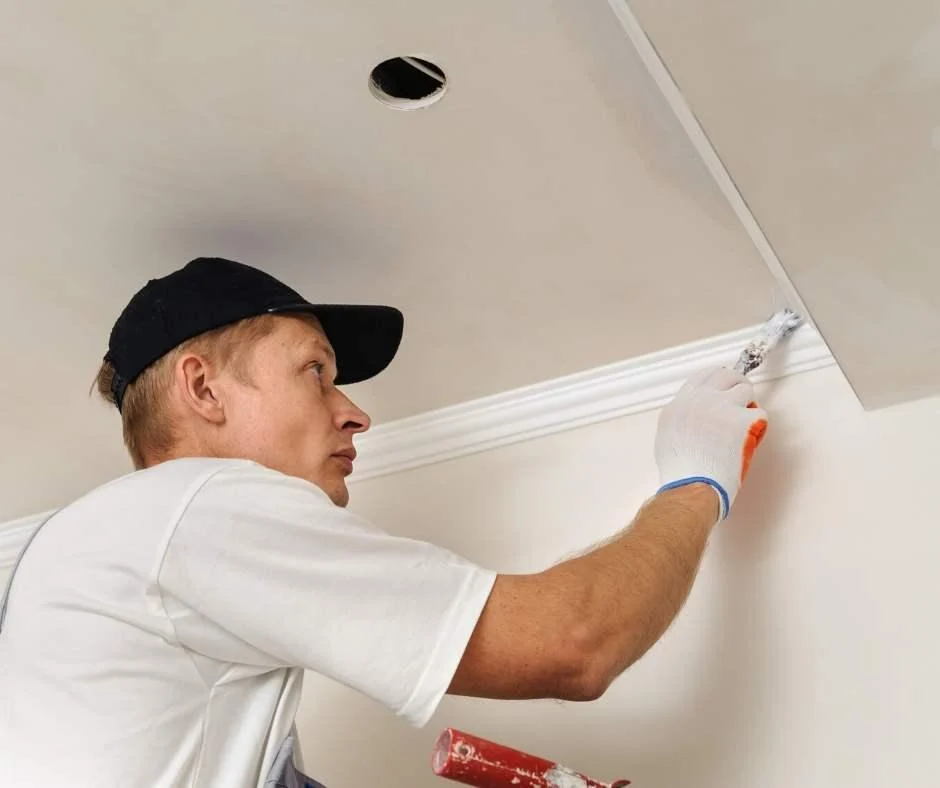 Plasterer fitting a length of cornice
