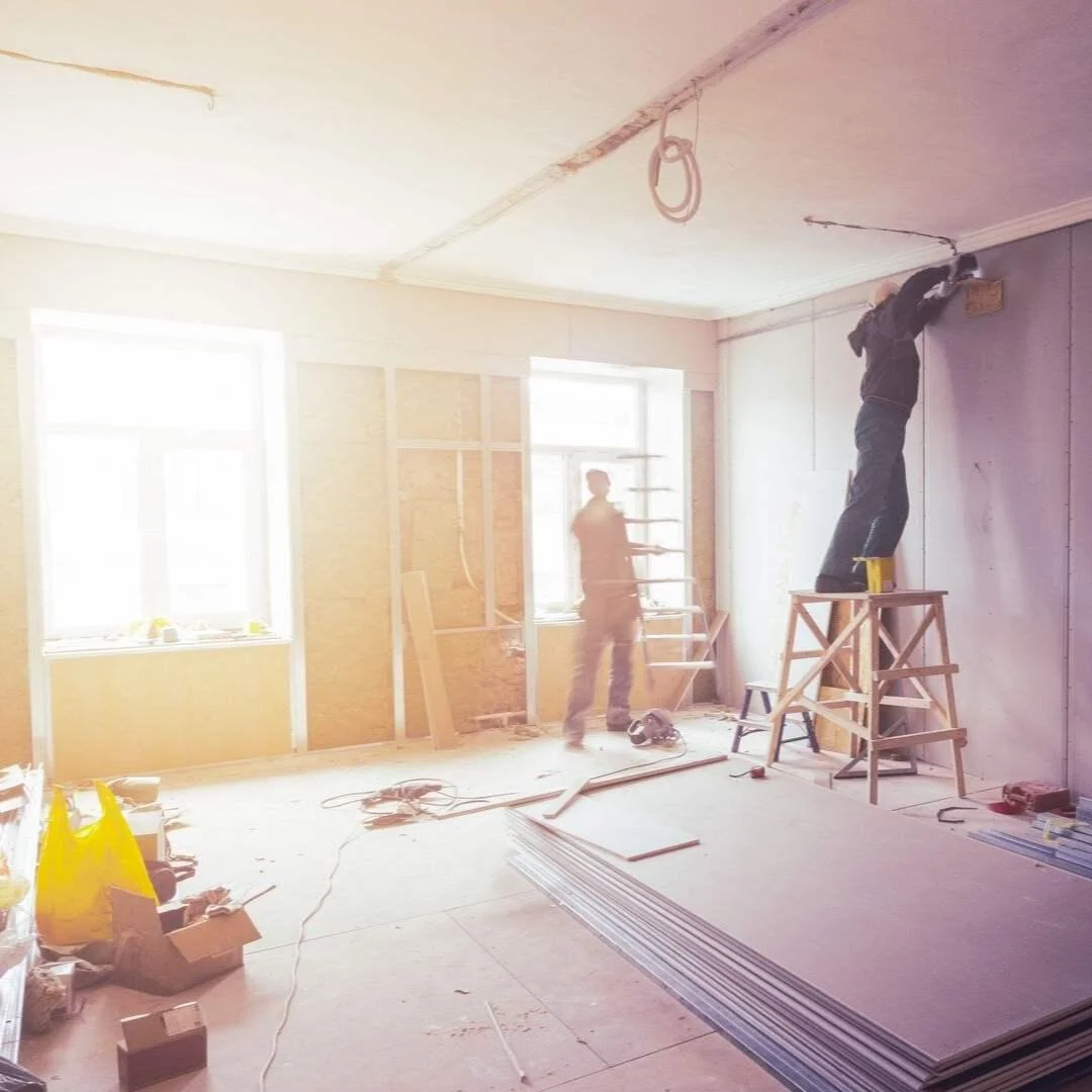 Tradesman at work on a wall in a sunny room