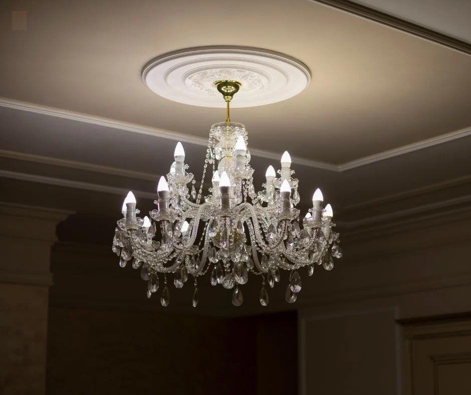 Ornate plaster ceiling rose and cornice around a hanging chandelier
